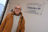 Maurice Ronze devant la plaque rendant hommage à ses parents adoptifs.|||