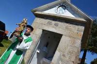lLe père Georges Volle avec la statue de Notre-Dame de Montjuvin devant l&#039;oratoire.