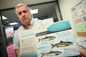 Alain Martin montre un panneau pour différencier la truite du tacon, un jeune saumon