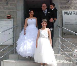 Les nouveaux mariés et leur petite famille à la sortie de la mairie.||Le petit Mathéo dans les bras de sa maman dont la robe en corolle fait un bien joli nid.||